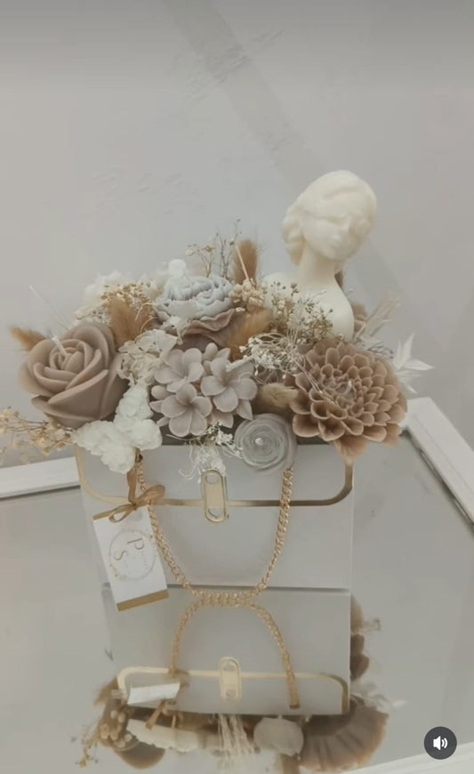 Bouquet floreale beige in borsetta bianca con dea bendata