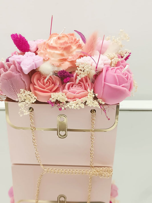 Composizione floreale di candele profumate rosa in borsetta rosa